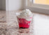 Clear plastic cup dessert with layered red fruit gelatin or jelly topped with whipped cream, served on a marble countertop at Lakeland Orchard
