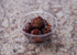 Clear plastic cup filled with barbecue glazed meatballs served on a marble countertop at Lakeland Orchard